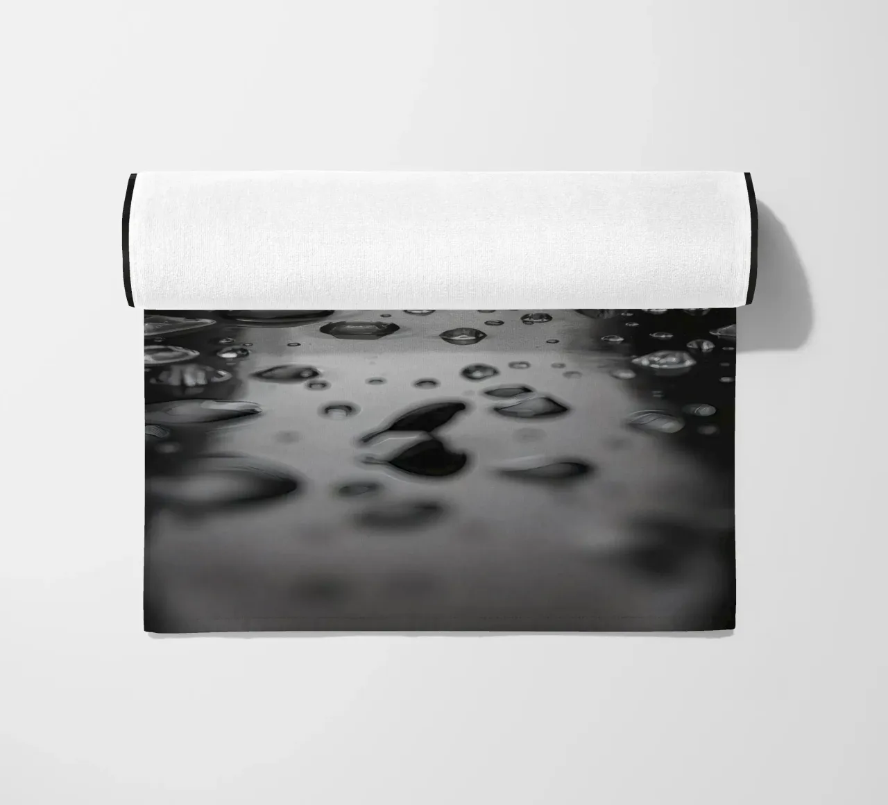 Raindrops creating reflections on a wet surface beach towel by DesignDoodle