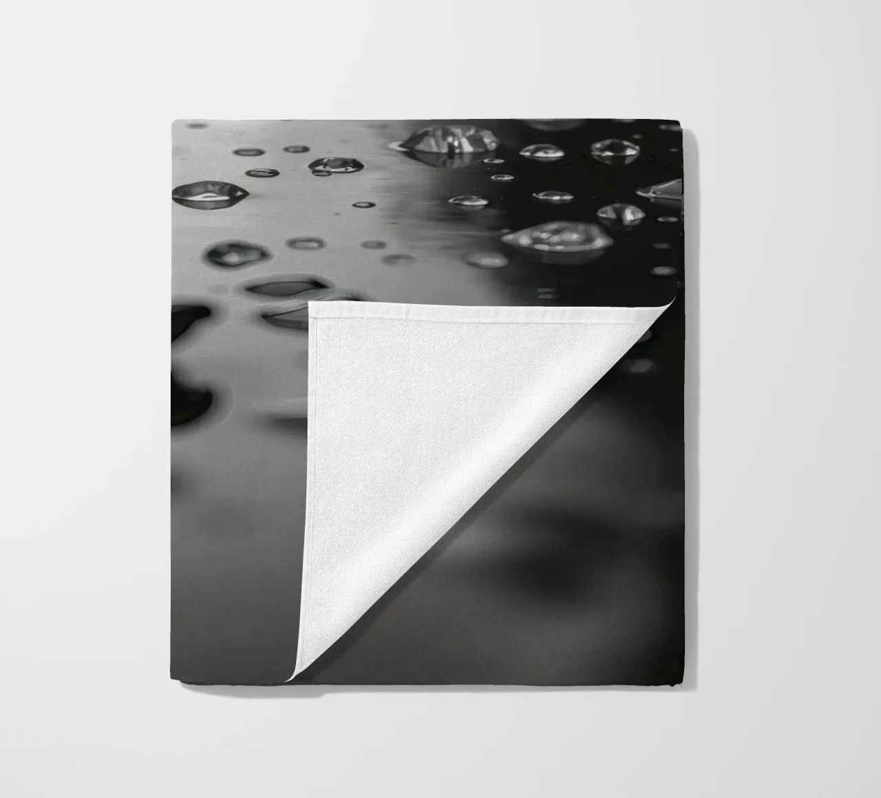 Raindrops creating reflections on a wet surface beach towel by DesignDoodle