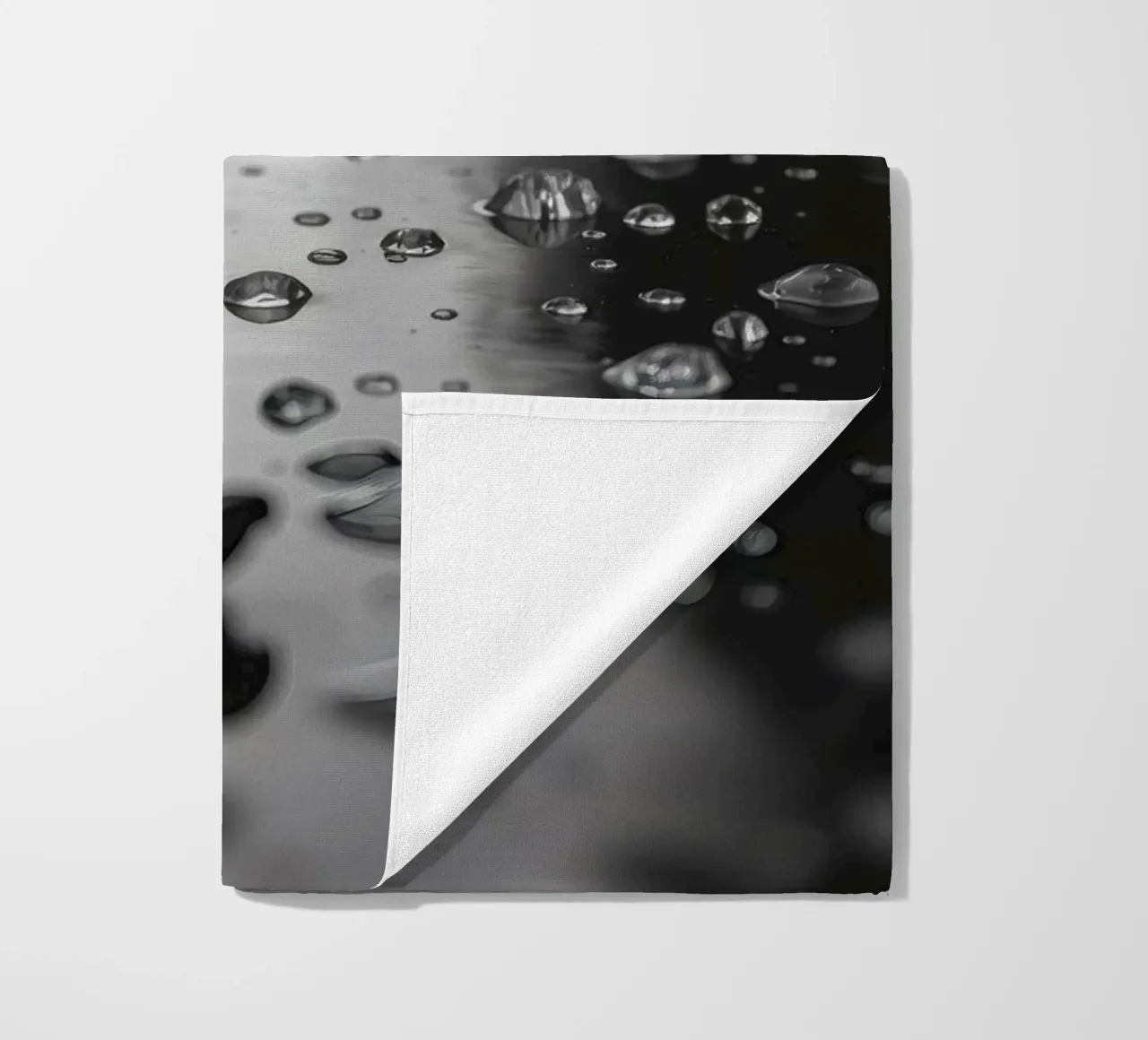 Raindrops creating reflections on a wet surface beach towel by DesignDoodle