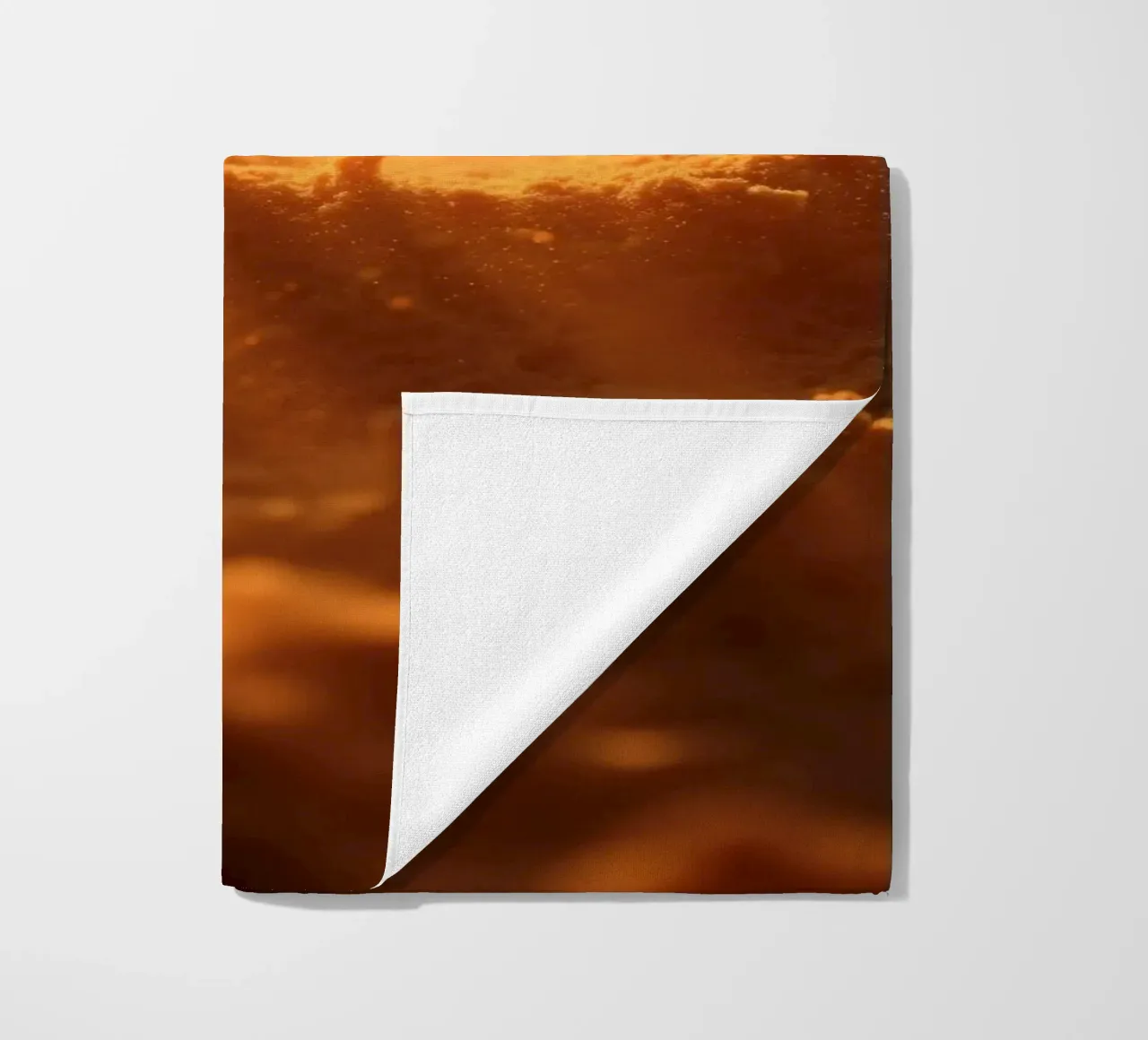 Sandige Textur, die von weichem Licht beleuchtet wird und ein warmes Gefühl vermittelt Strandtuch von DesignDoodle