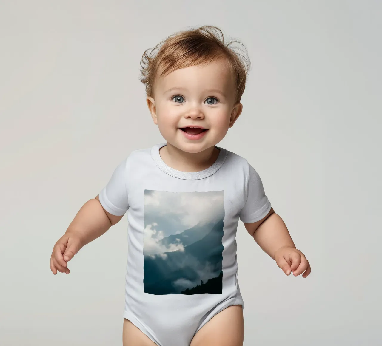 Mountain landscape with mist and clouds creating a serene short-sleeve baby romper by DesignDoodle