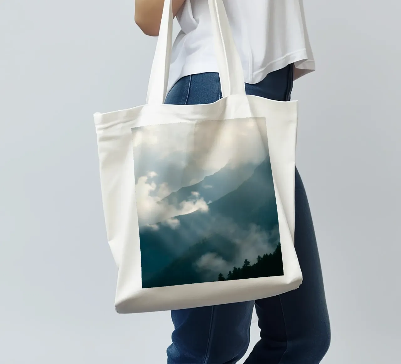 Mountain landscape with mist and clouds creating a serene tote bag by DesignDoodle