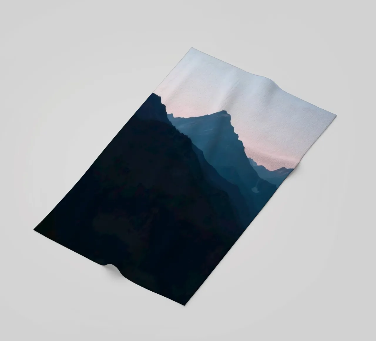Serene mountain silhouettes at dusk create a tranquil feel beach towel by DesignDoodle