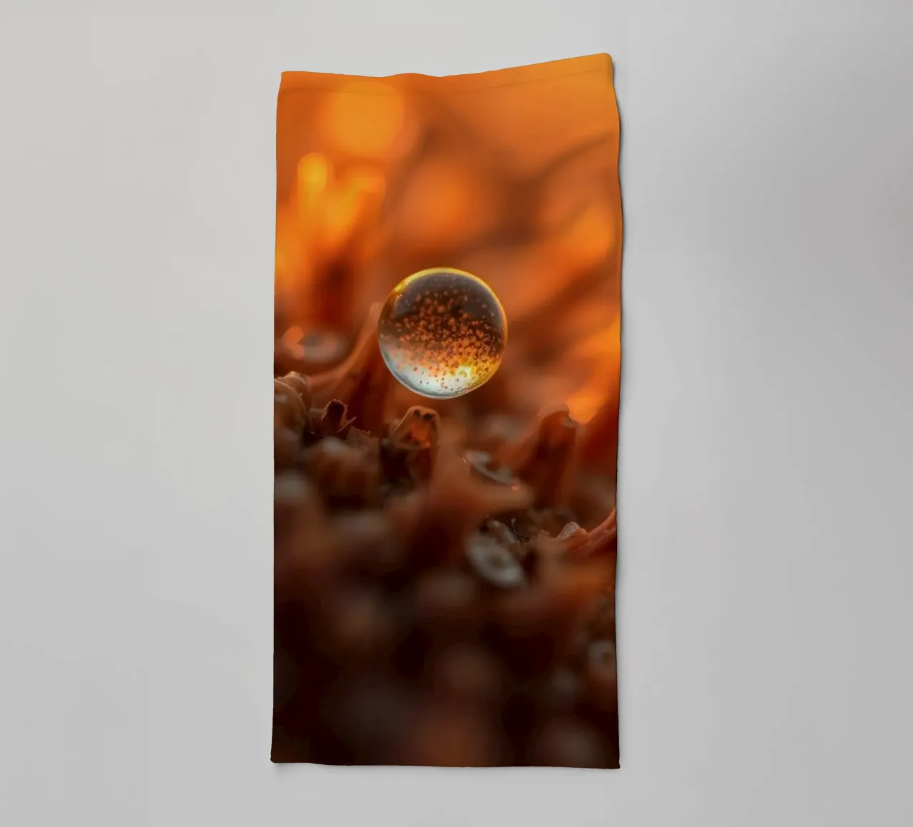 Captured dew drop reflecting warm tones on plant surface towel by DesignDoodle