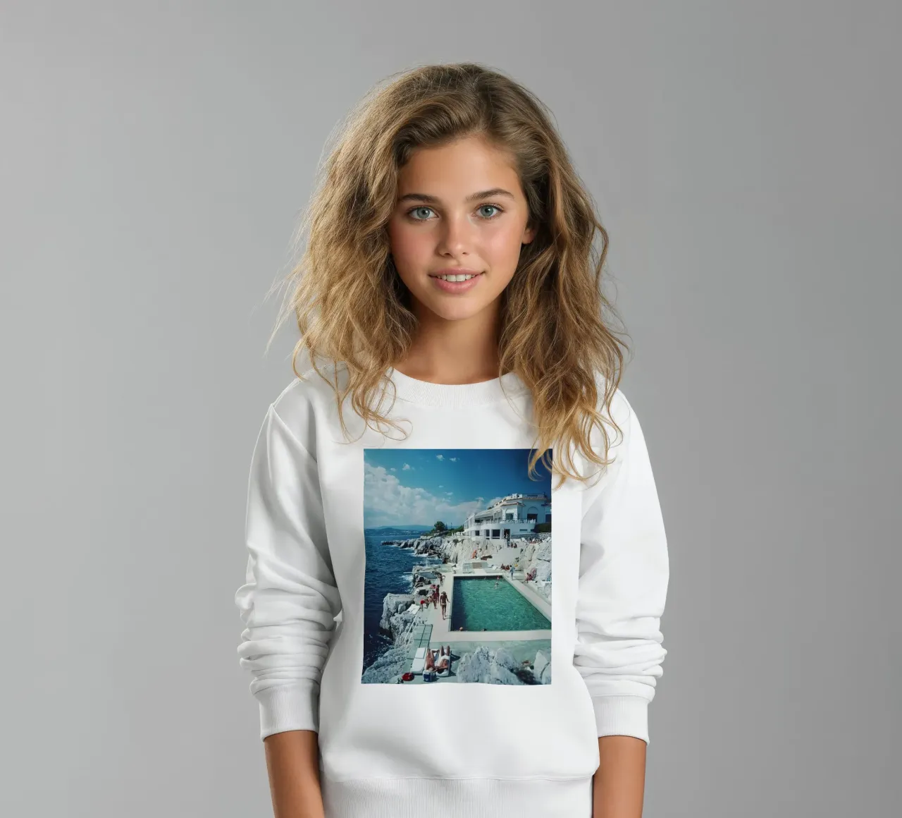 Tomar el sol en la piscina junto a la playa Antibes, 1976 - Slim Aarons sudadera para niño de The Poster UK