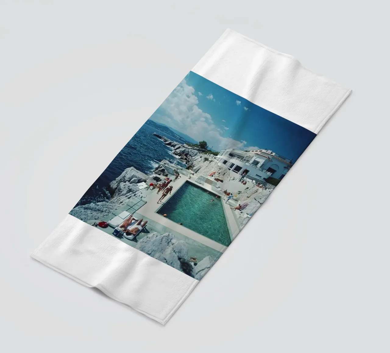 Sunbathing at the Beachside Pool Antibes, 1976 - Slim Aarons beach towel by The Poster UK