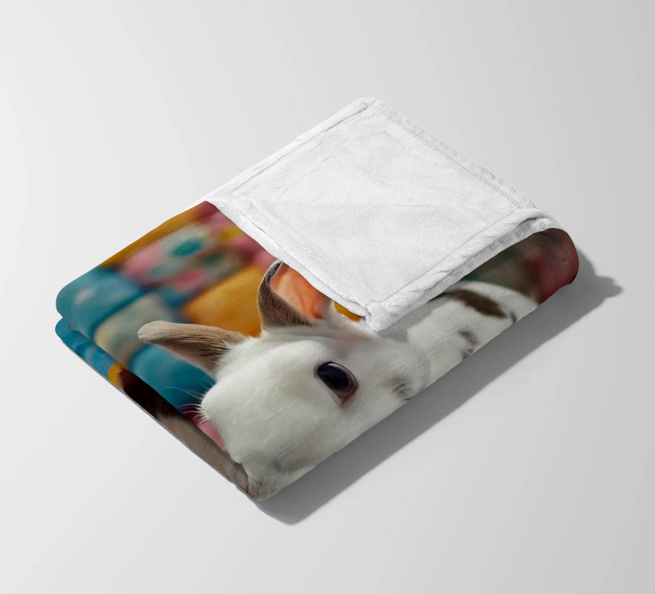Due adorabili conigli seduti su un'accogliente trapunta colorata coperta in pile da DesignDoodle