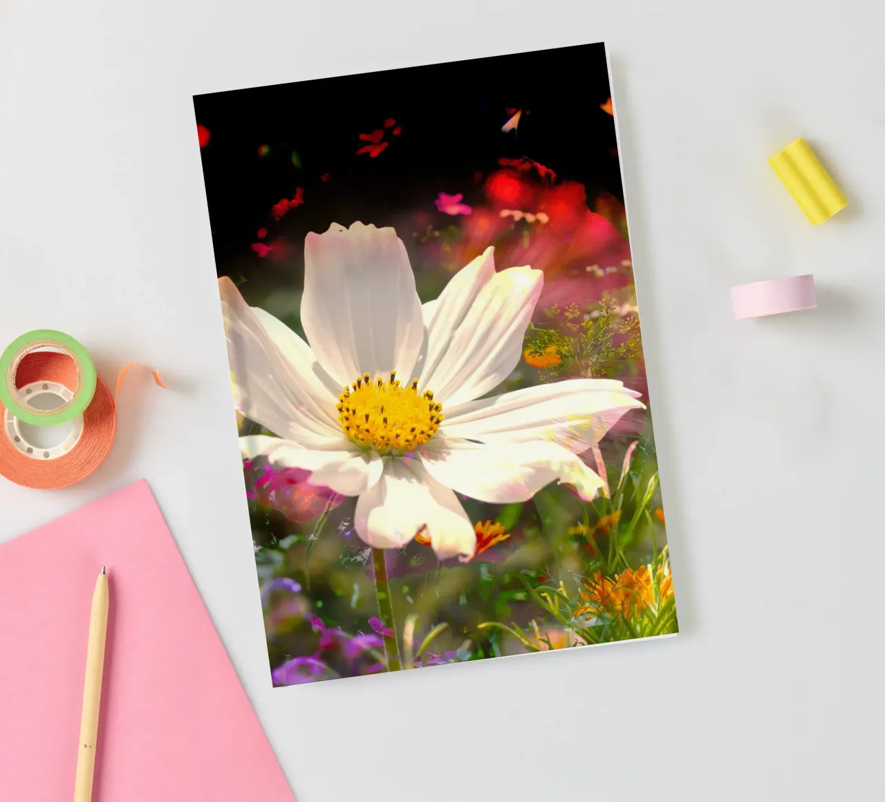 white flower stands brightly in the centre of a field of flowers notebook by NA/MO