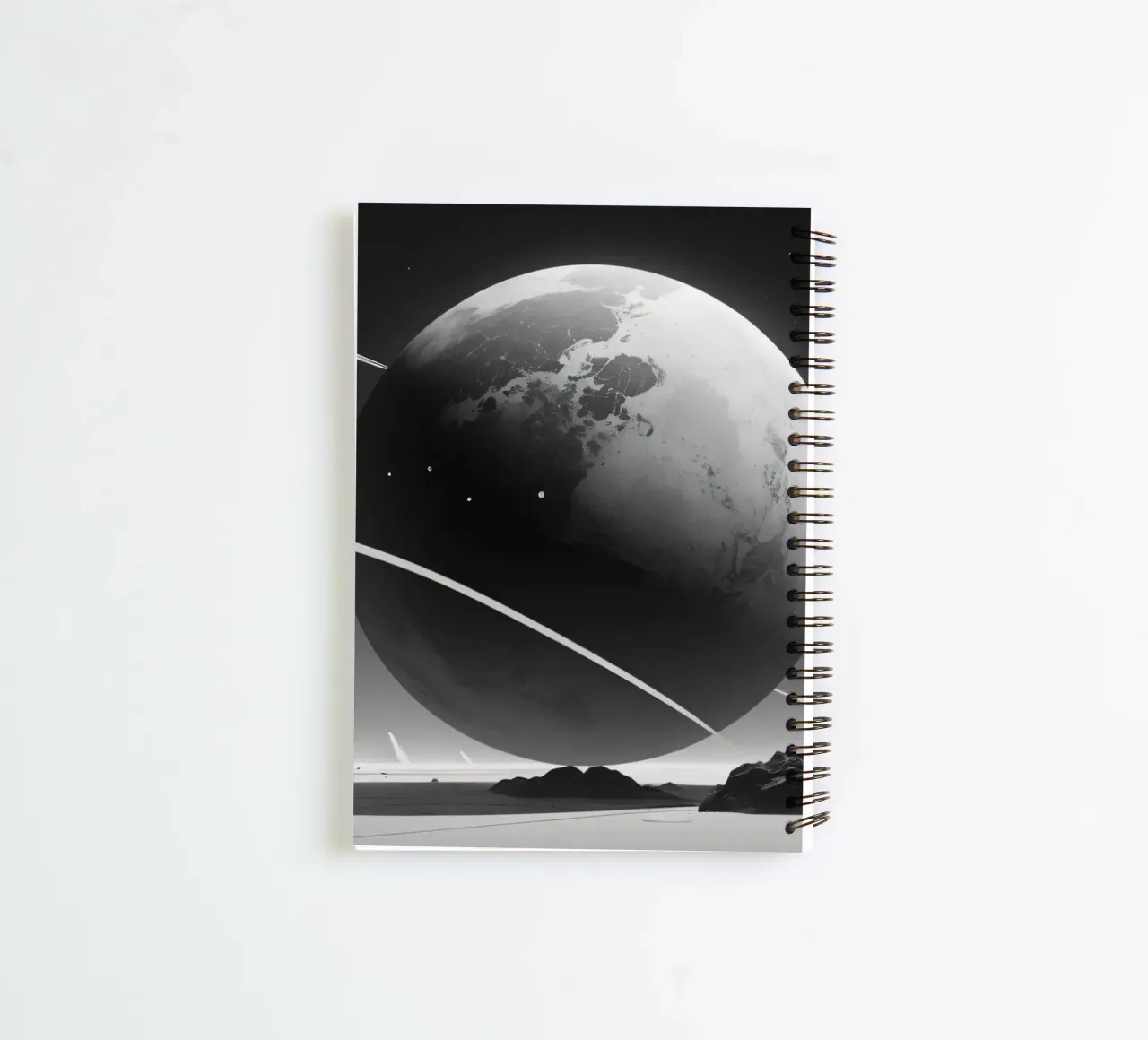planet with rings hovering over a desolate landscape under a spiral notebook by DesignDoodle