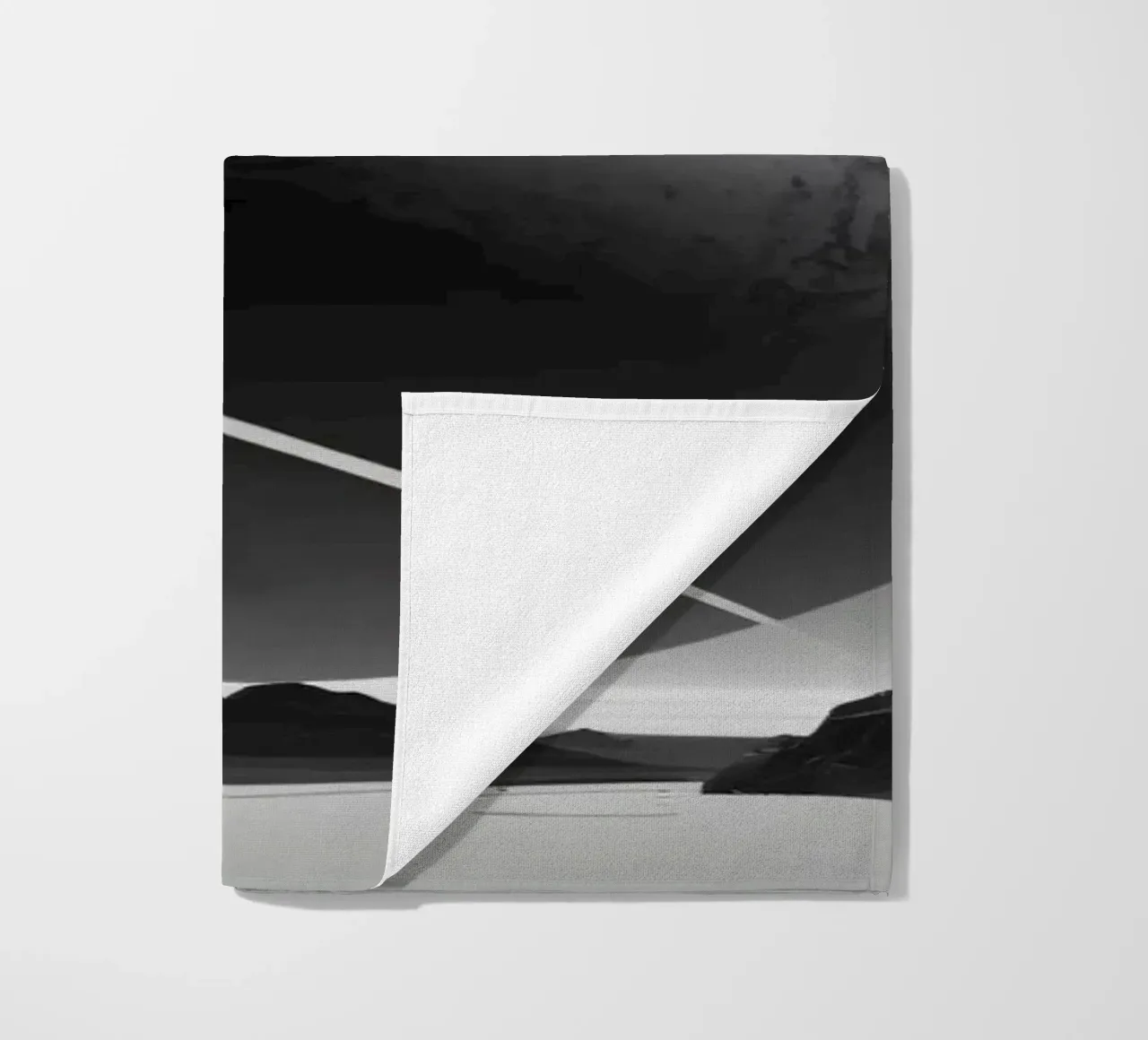 planet with rings hovering over a desolate landscape under a beach towel by DesignDoodle