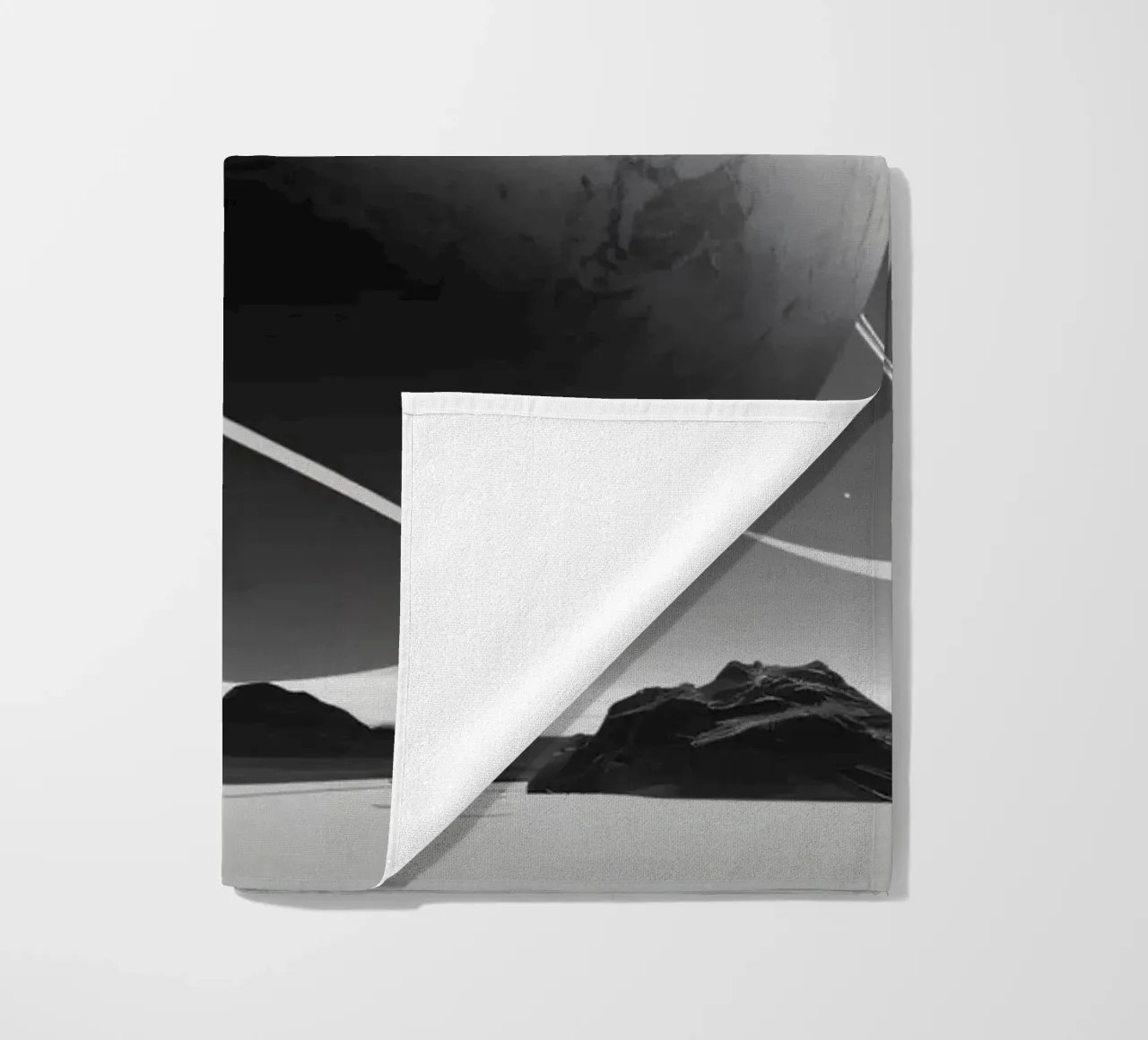 planet with rings hovering over a desolate landscape under a beach towel by DesignDoodle