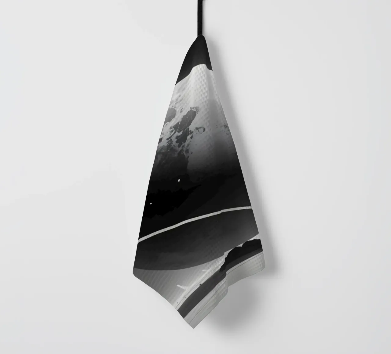 Planet mit Ringen, der über einer trostlosen Landschaft unter einer Geschirrtuch von DesignDoodle