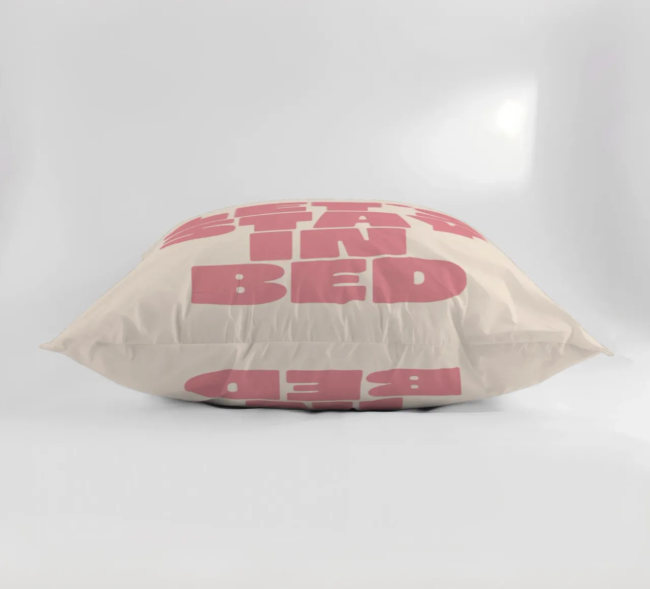 Stampa tipografica della parete della camera da letto rosa pesca "Let's Stay in Bed". cuscino da THE MOTIVATED TYPE