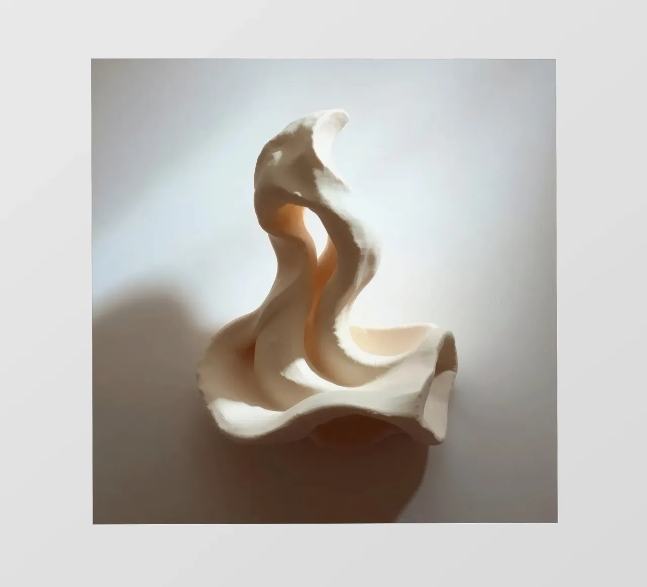Elegante pezzo scultoreo bianco che mostra forme fluide pellicola backlit da DesignDoodle