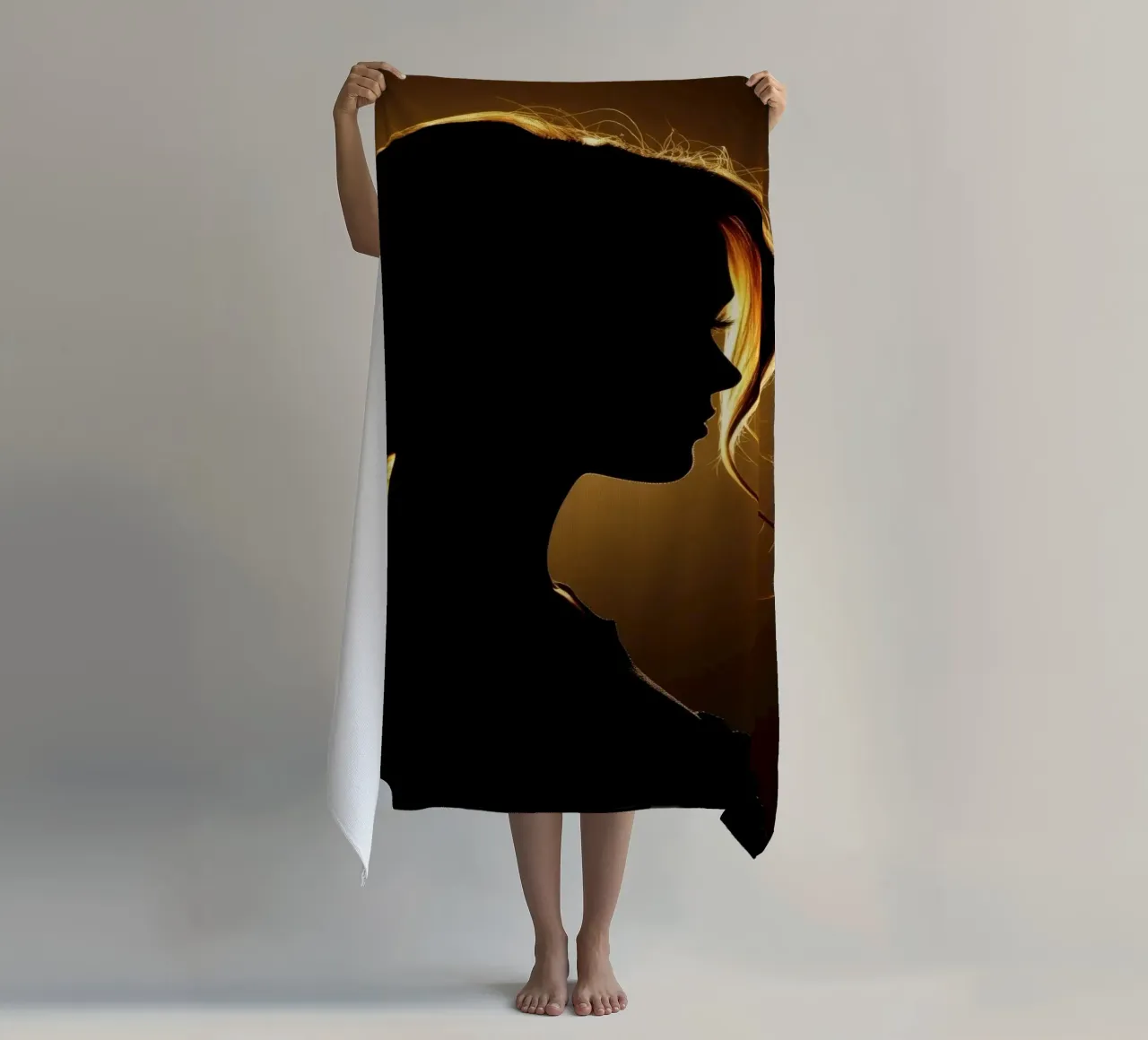 Silhouette di una donna con capelli fluenti illuminata da una luce calda telo mare da DesignDoodle