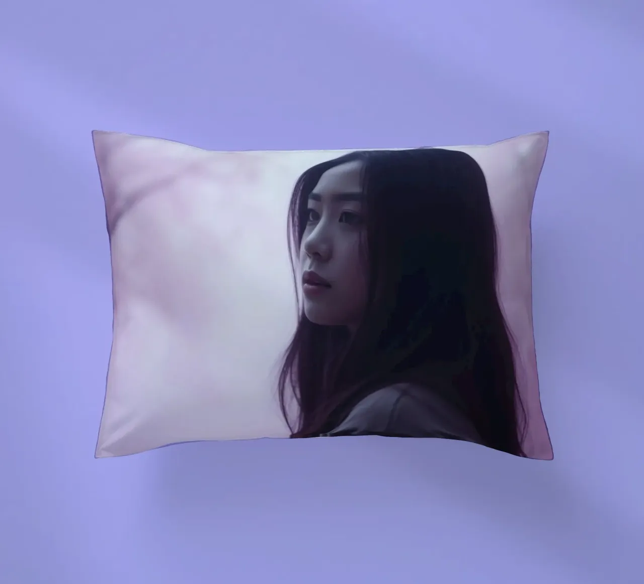Una giovane donna guarda pensierosa in una foresta nebbiosa di colore viola, mentre cuscino da DesignDoodle