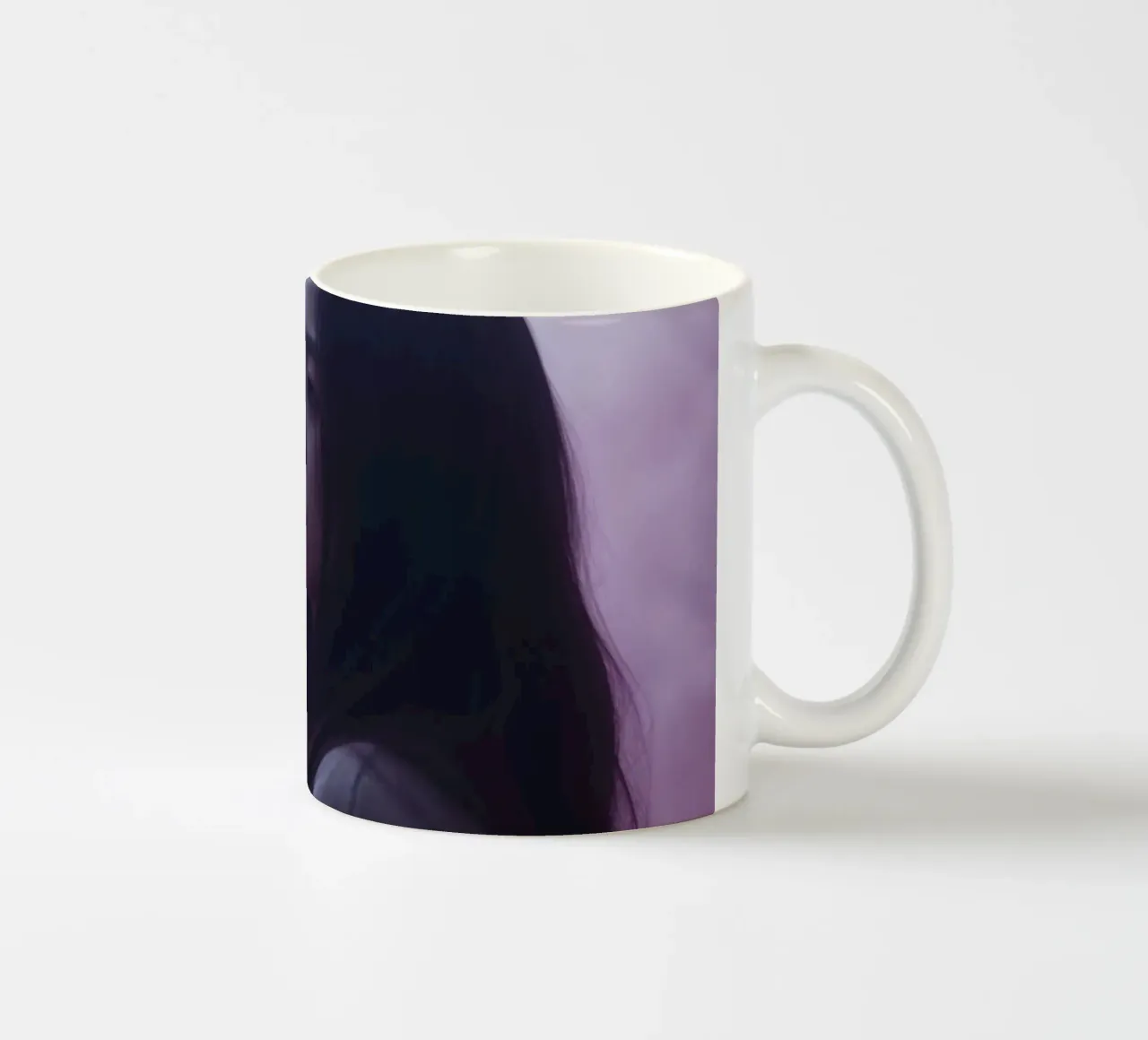 Una giovane donna guarda pensierosa in una foresta nebbiosa di colore viola, mentre tazza in ceramica da DesignDoodle