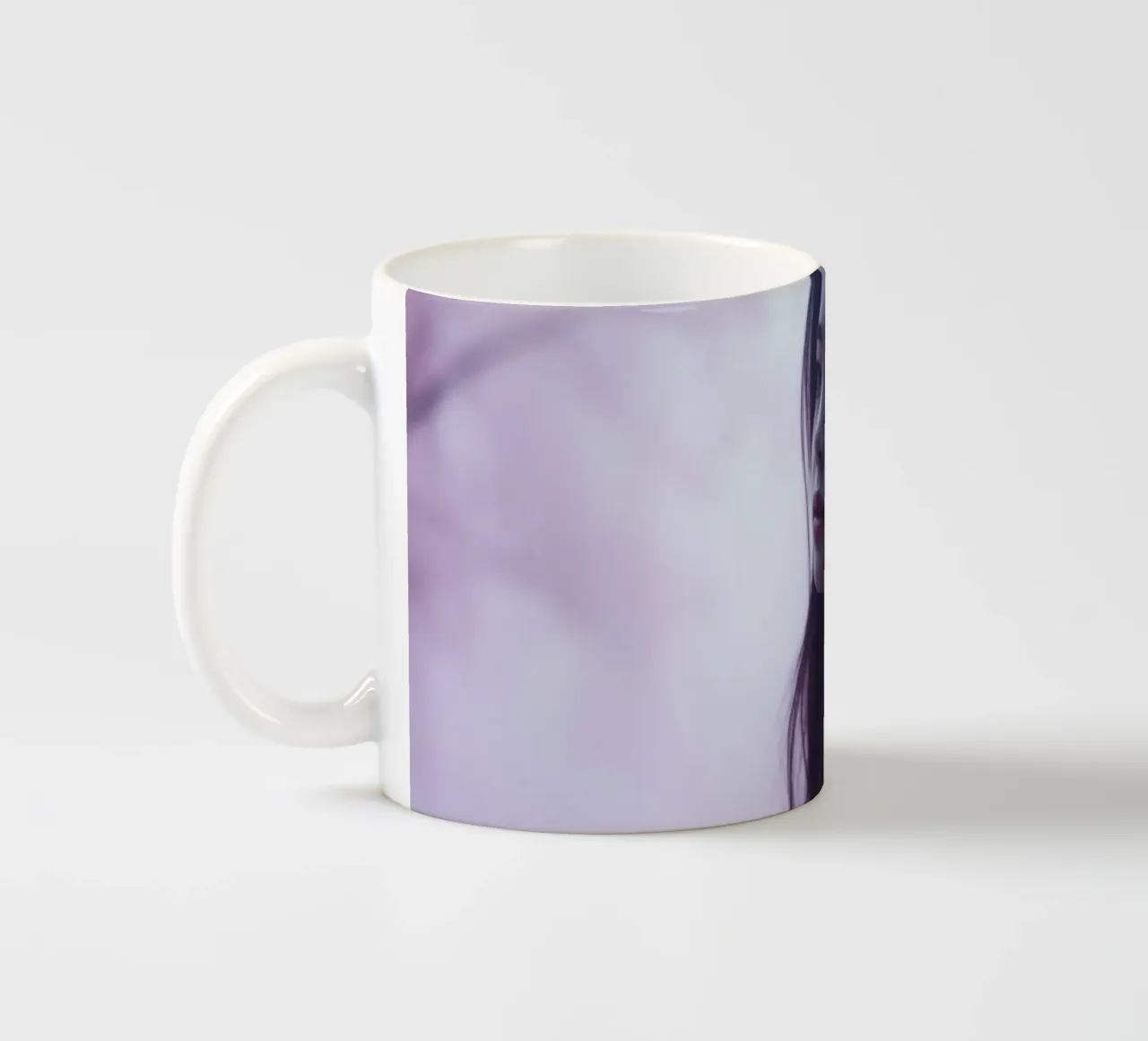 Una giovane donna guarda pensierosa in una foresta nebbiosa di colore viola, mentre tazza in ceramica da DesignDoodle