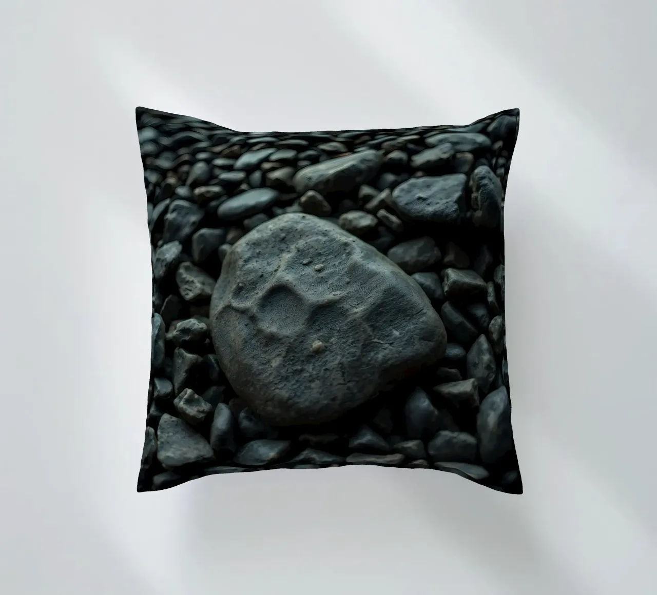 Pietre scure sparse su una spiaggia al tramonto cuscino da DesignDoodle