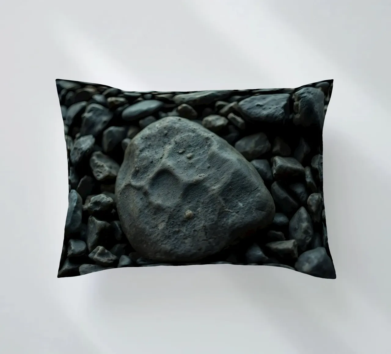 Pietre scure sparse su una spiaggia al tramonto cuscino da DesignDoodle