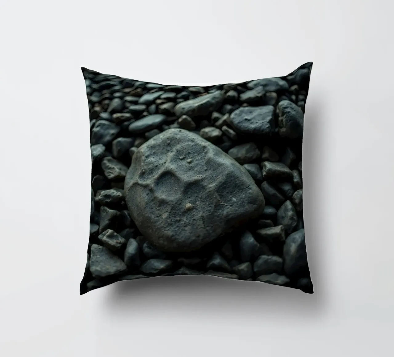 Pietre scure sparse su una spiaggia al tramonto cuscino da DesignDoodle