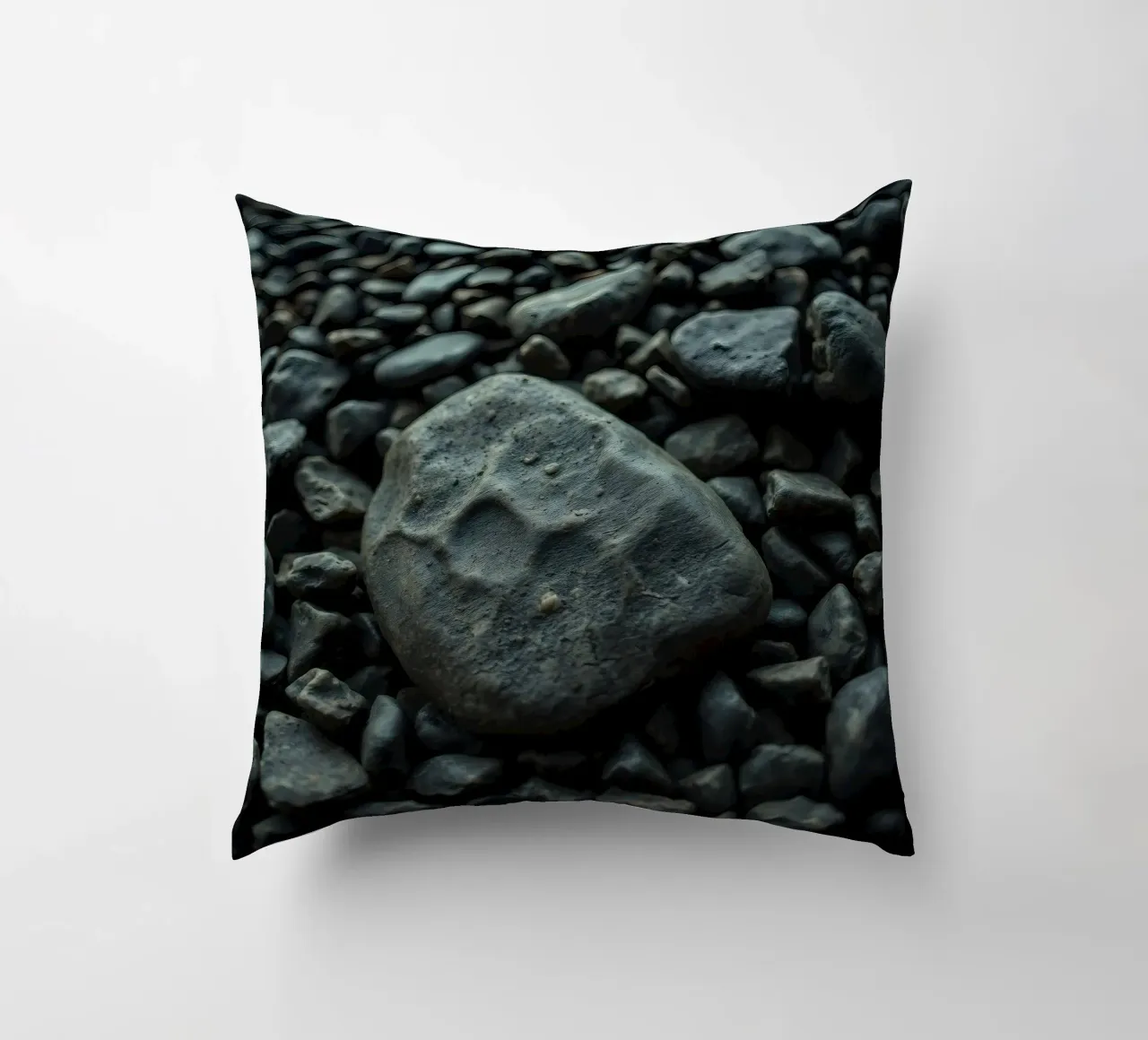 Pietre scure sparse su una spiaggia al tramonto cuscino da DesignDoodle