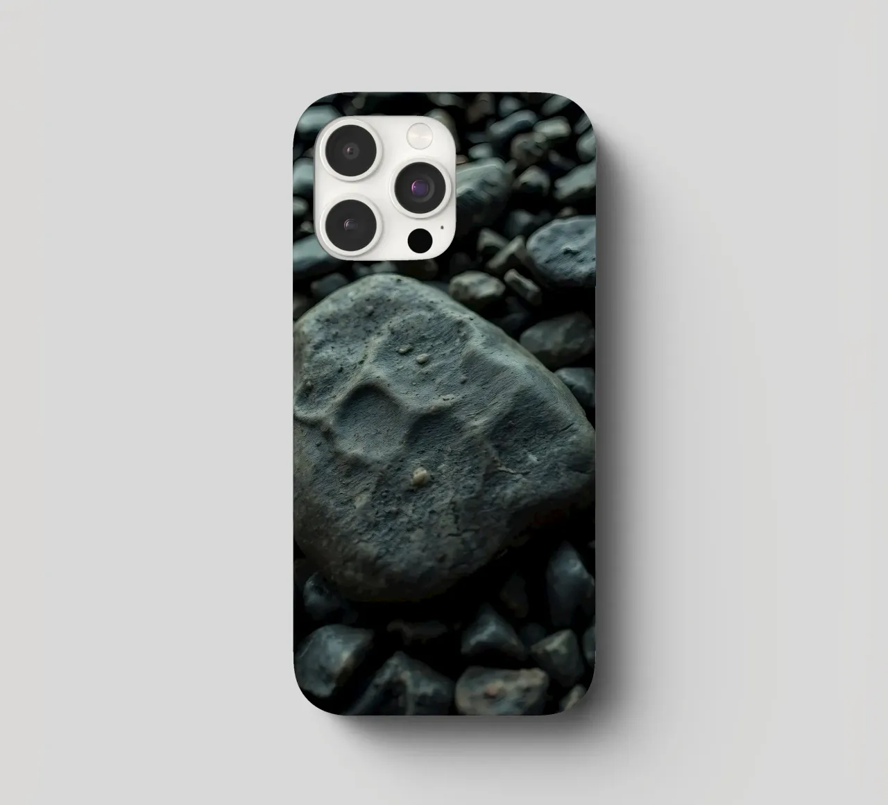 Pietre scure sparse su una spiaggia al tramonto cover iphone da DesignDoodle