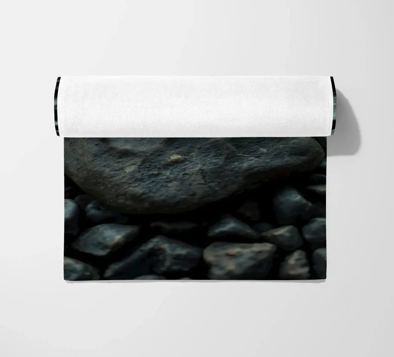 Pietre scure sparse su una spiaggia al tramonto telo mare da DesignDoodle