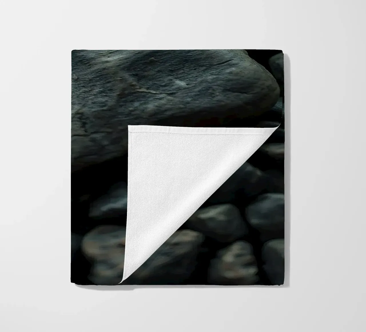 Pietre scure sparse su una spiaggia al tramonto telo mare da DesignDoodle