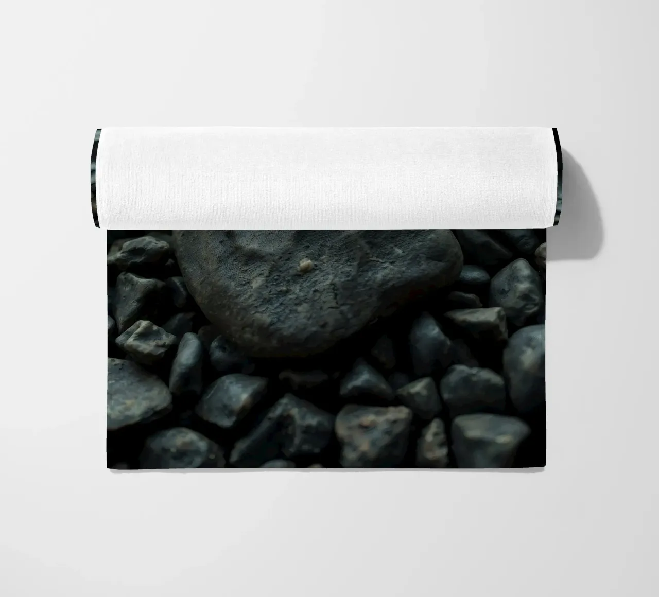 Pietre scure sparse su una spiaggia al tramonto telo mare da DesignDoodle