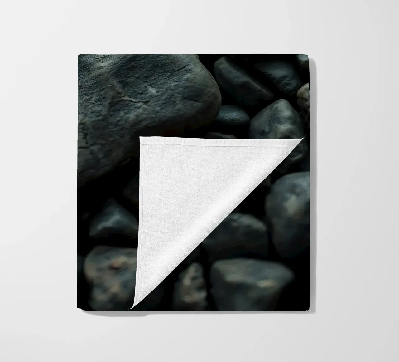 Pietre scure sparse su una spiaggia al tramonto telo mare da DesignDoodle