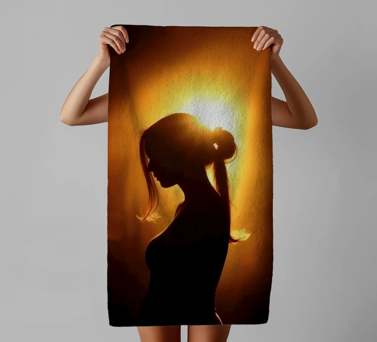 Silhouette of a woman against a warm glowing backdrop towel by DesignDoodle
