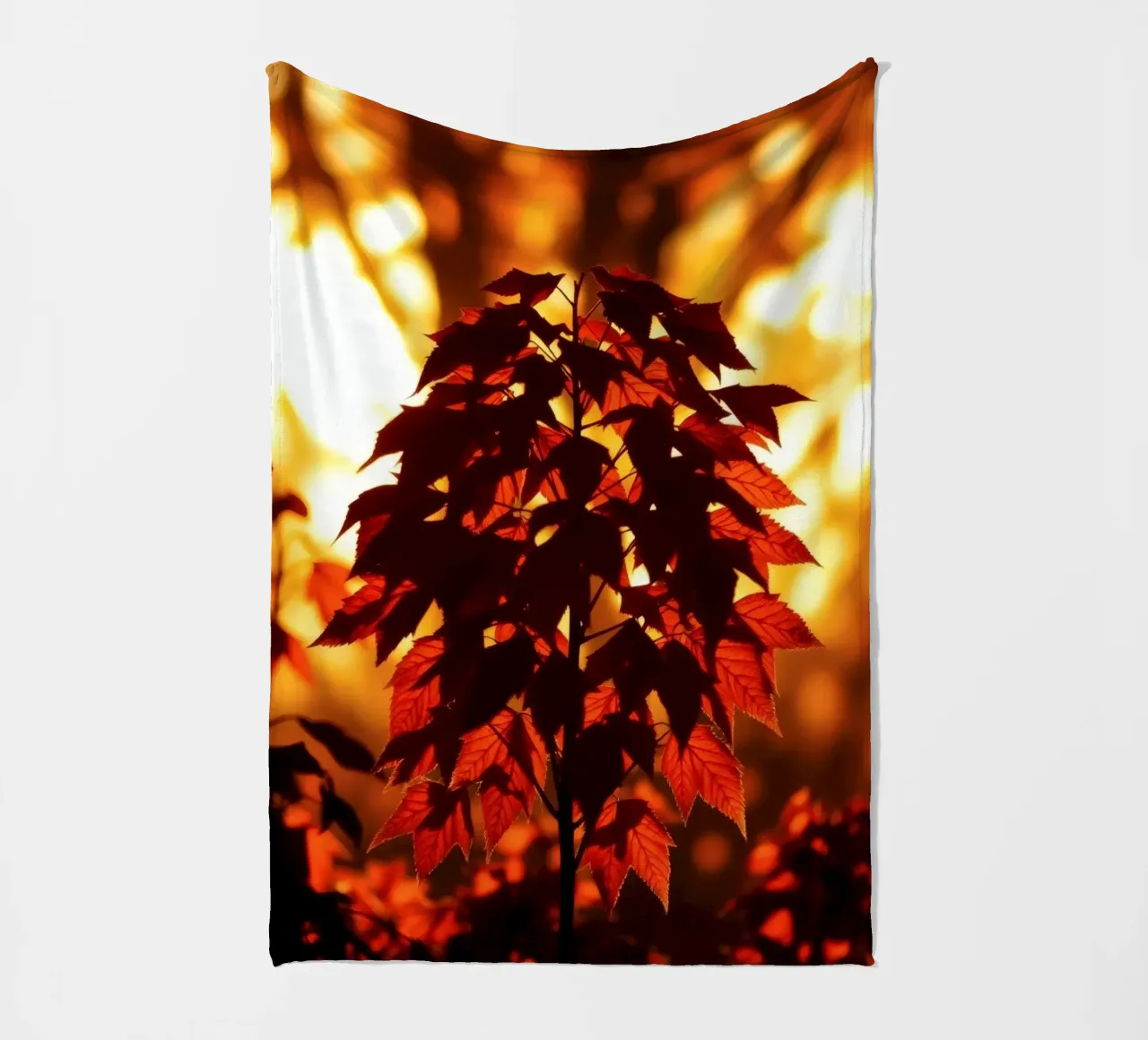 Silhouette di foglie autunnali contro un tramonto luminoso coperta in pile da DesignDoodle