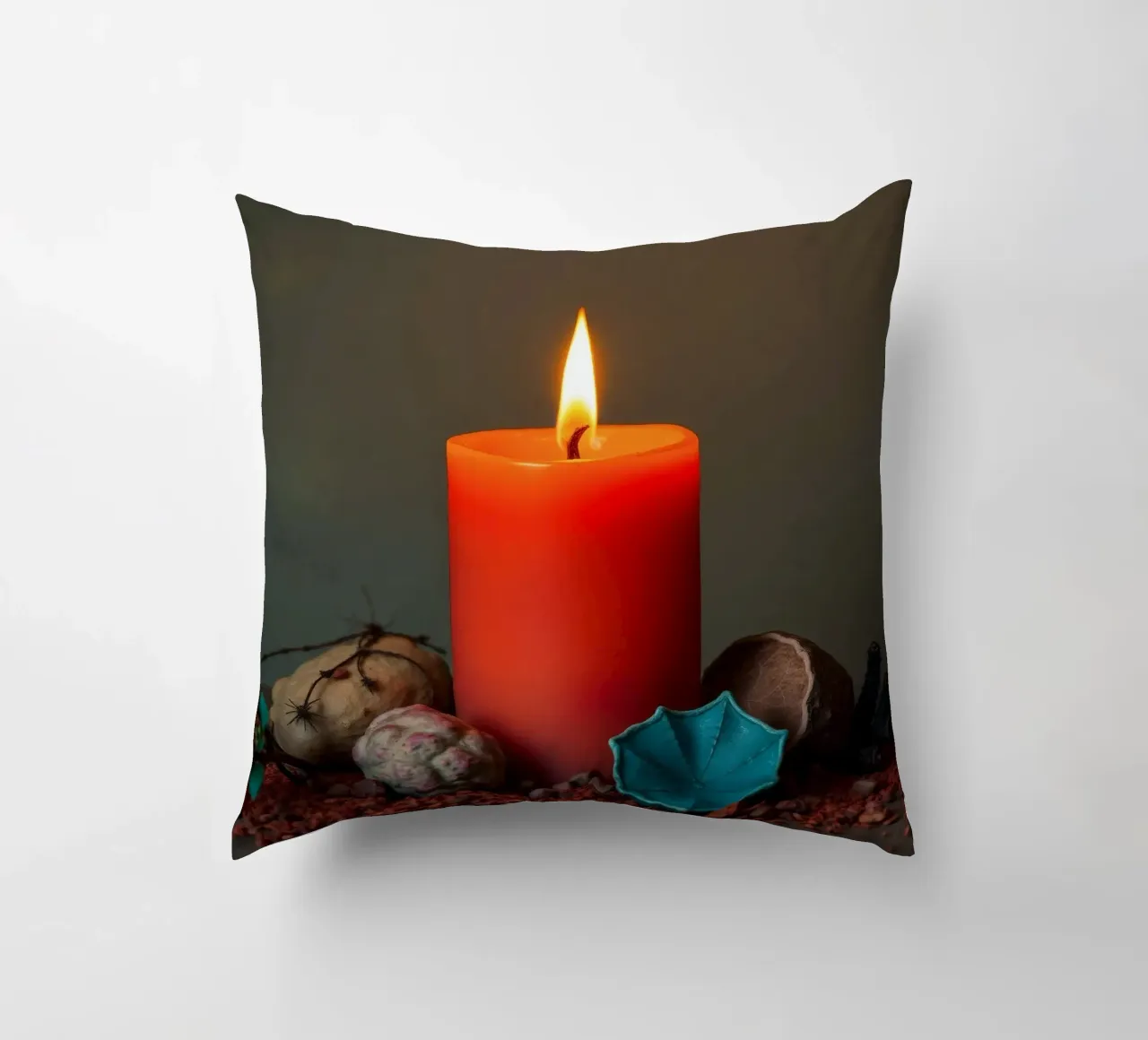 Bright orange candle surrounded by decorative stones decorative cushion by DesignDoodle