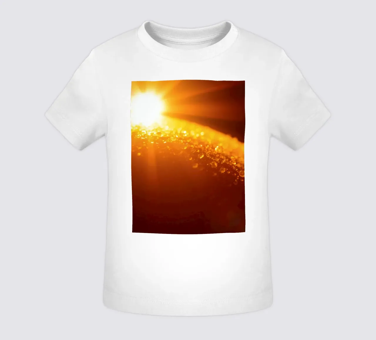 Sunlight glistens on a dewy surface at dawn, creating a warm baby t-shirt by DesignDoodle