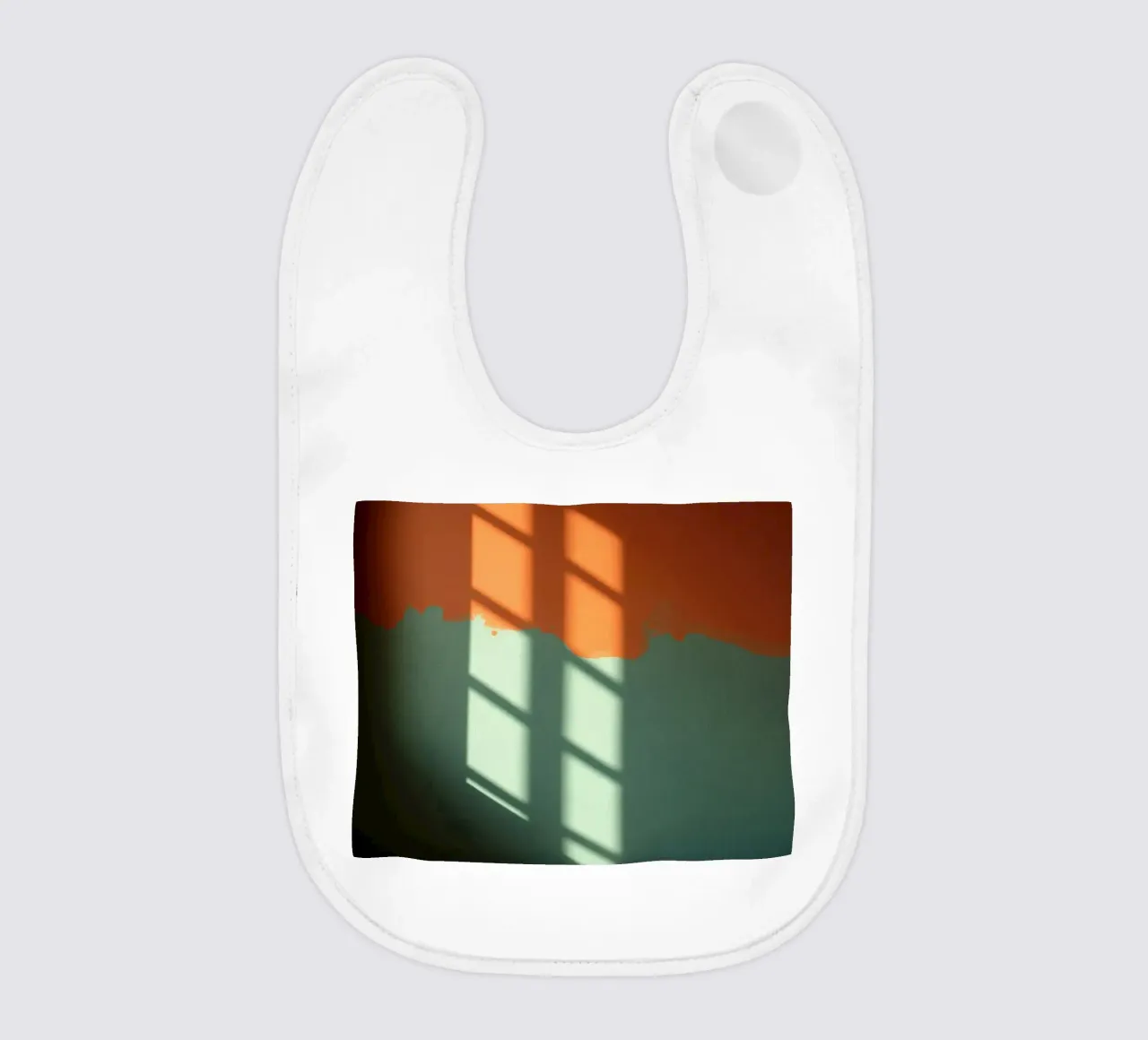 Gioco di luci e ombre su una parete colorata in una stanza illuminata dal sole. bavaglino da DesignDoodle