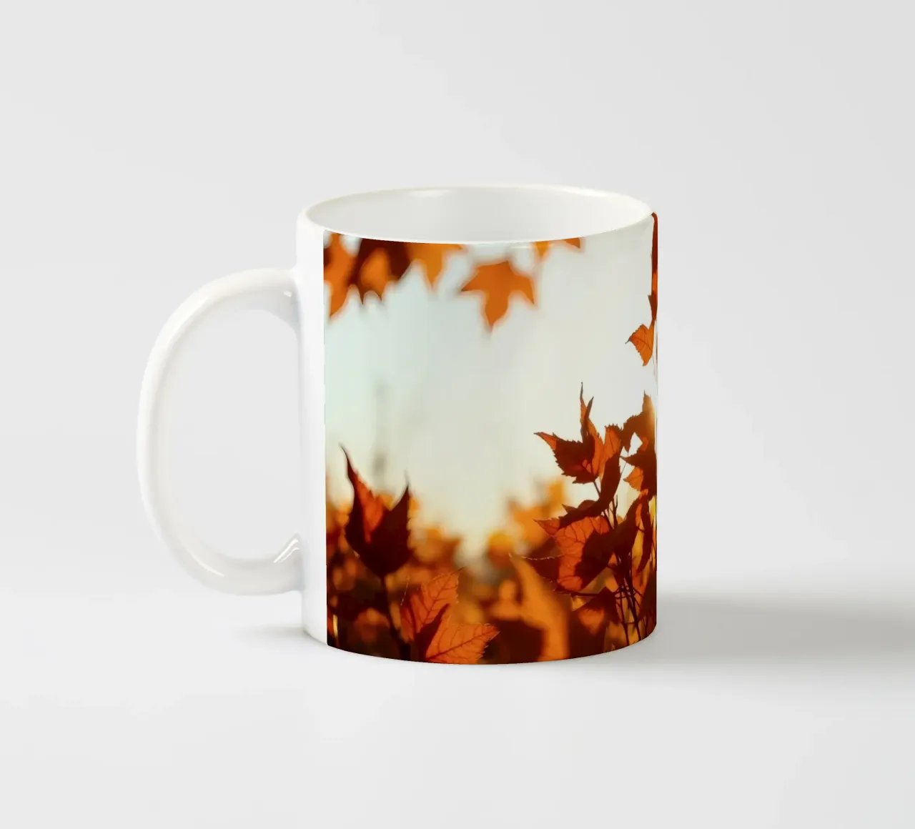 Foglie d'autunno illuminate dalla luce del sole in un ambiente tranquillo. tazza in ceramica da DesignDoodle