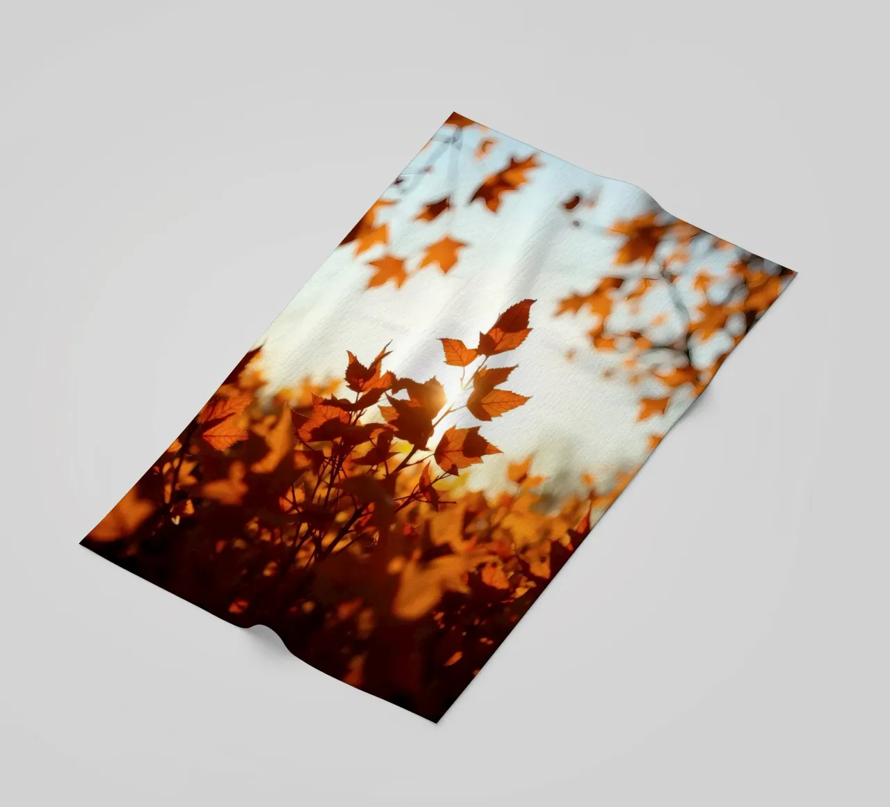 Foglie d'autunno illuminate dalla luce del sole in un ambiente tranquillo. telo mare da DesignDoodle