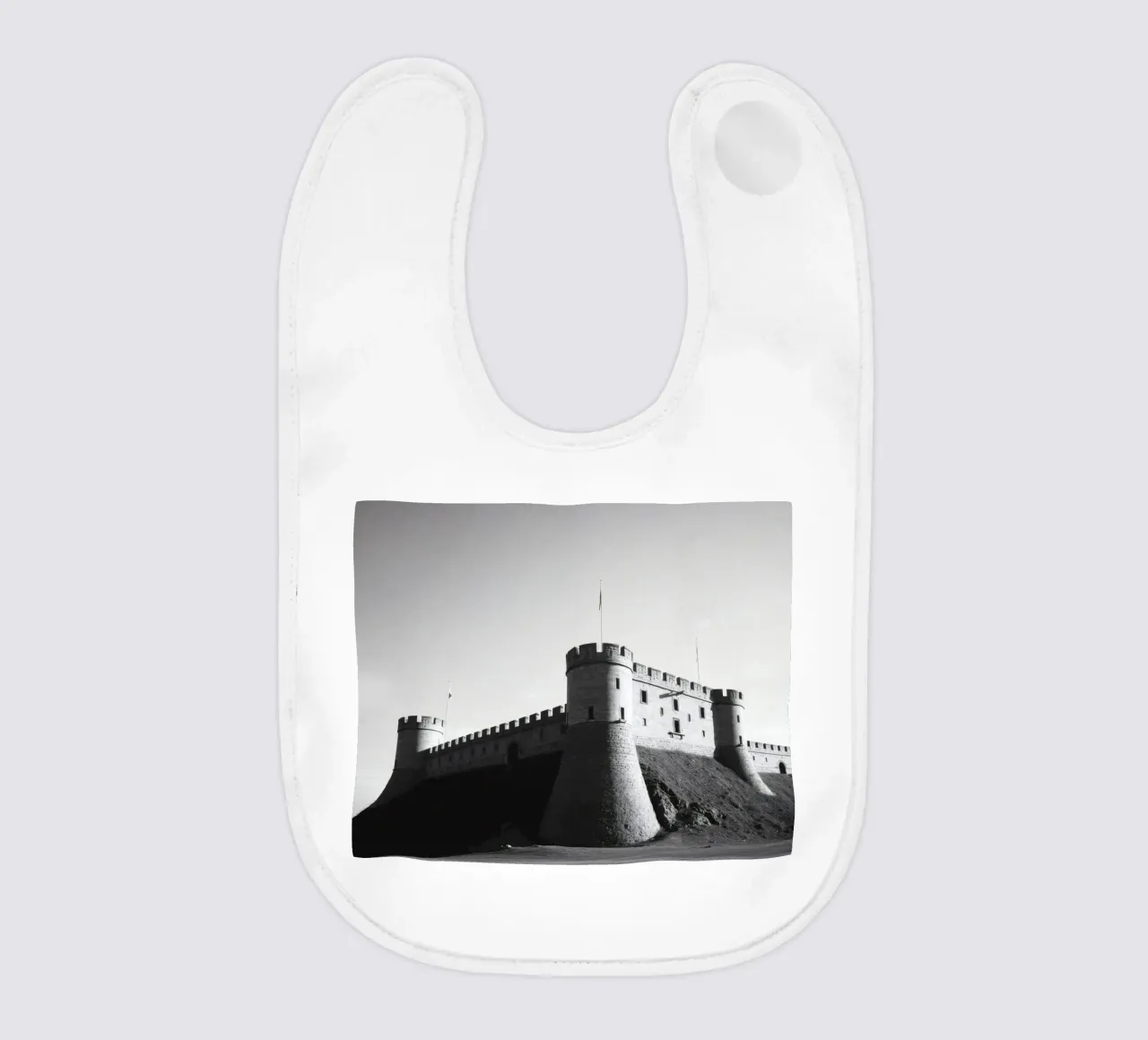 Lo storico castello in pietra si erge sulla cima di una collina sotto un cielo limpido bavaglino da DesignDoodle