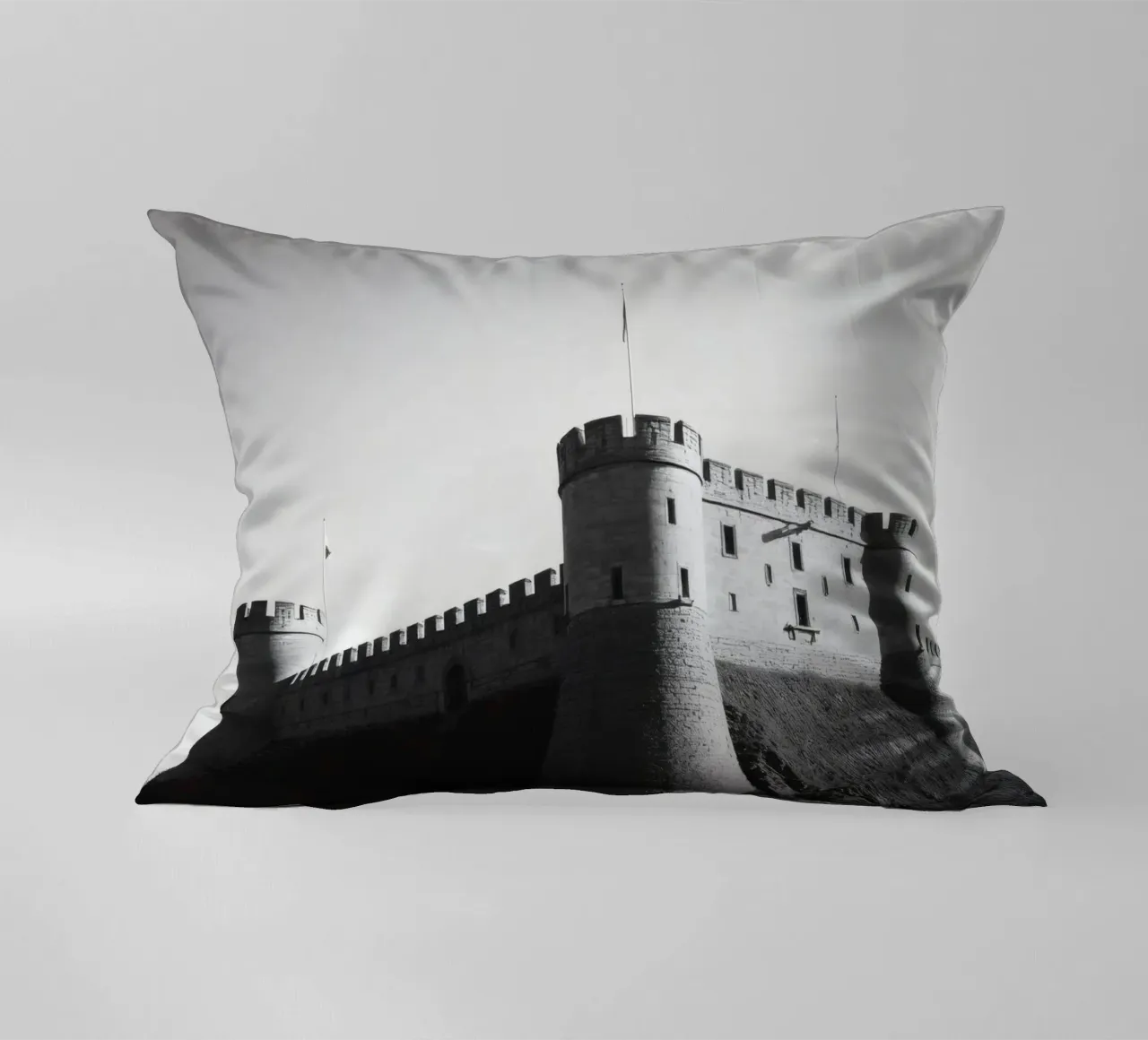 Lo storico castello in pietra si erge sulla cima di una collina sotto un cielo limpido cuscino da DesignDoodle