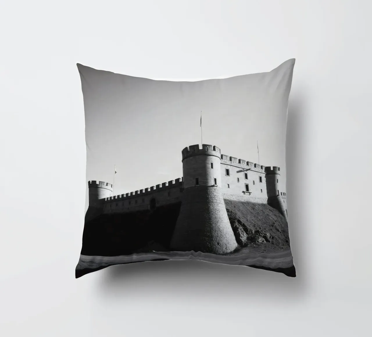 Lo storico castello in pietra si erge sulla cima di una collina sotto un cielo limpido cuscino da DesignDoodle