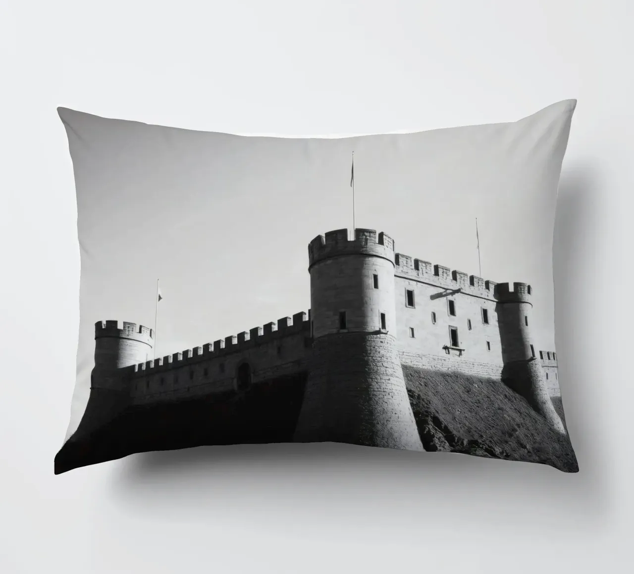 Lo storico castello in pietra si erge sulla cima di una collina sotto un cielo limpido cuscino da DesignDoodle