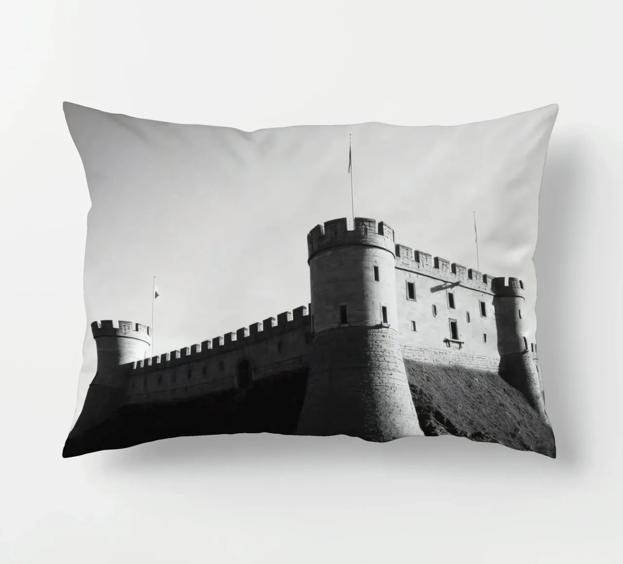 Lo storico castello in pietra si erge sulla cima di una collina sotto un cielo limpido cuscino da DesignDoodle