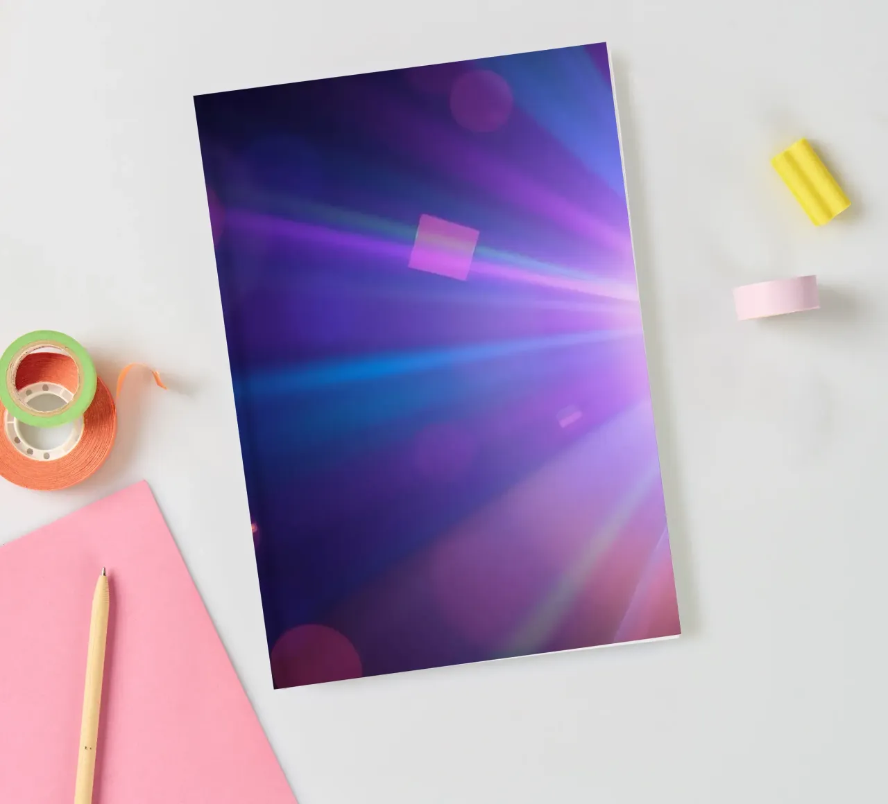 Colorful light rays create a vibrant display in a dark art notebook by DesignDoodle