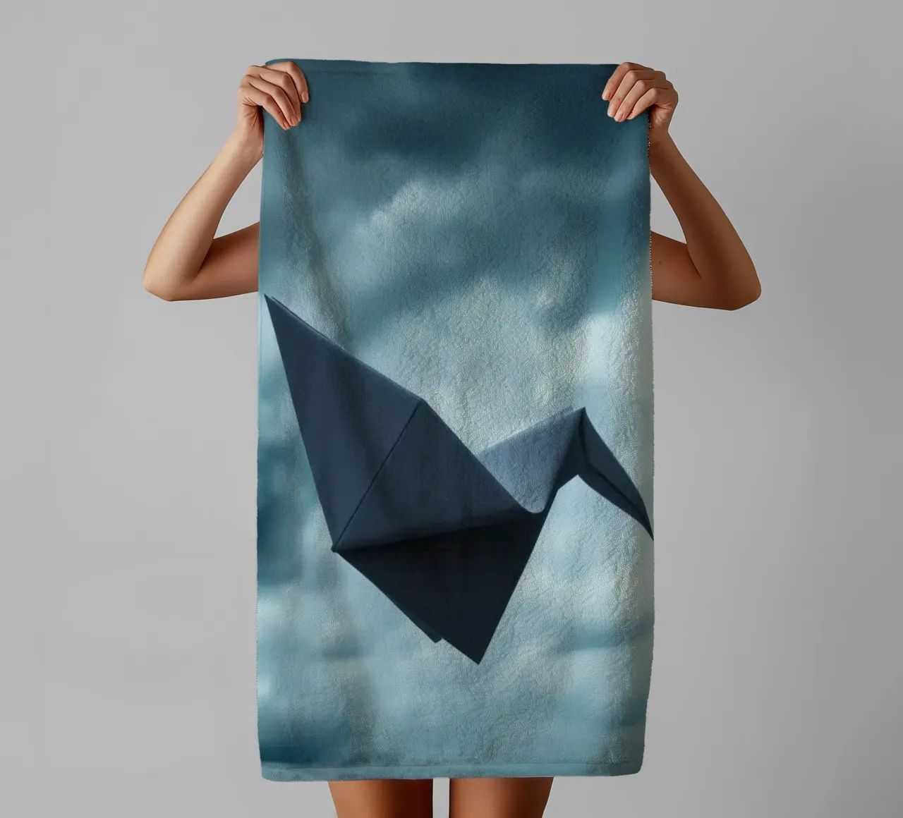 Floating origami crane against a dramatic cloudy sky towel by DesignDoodle