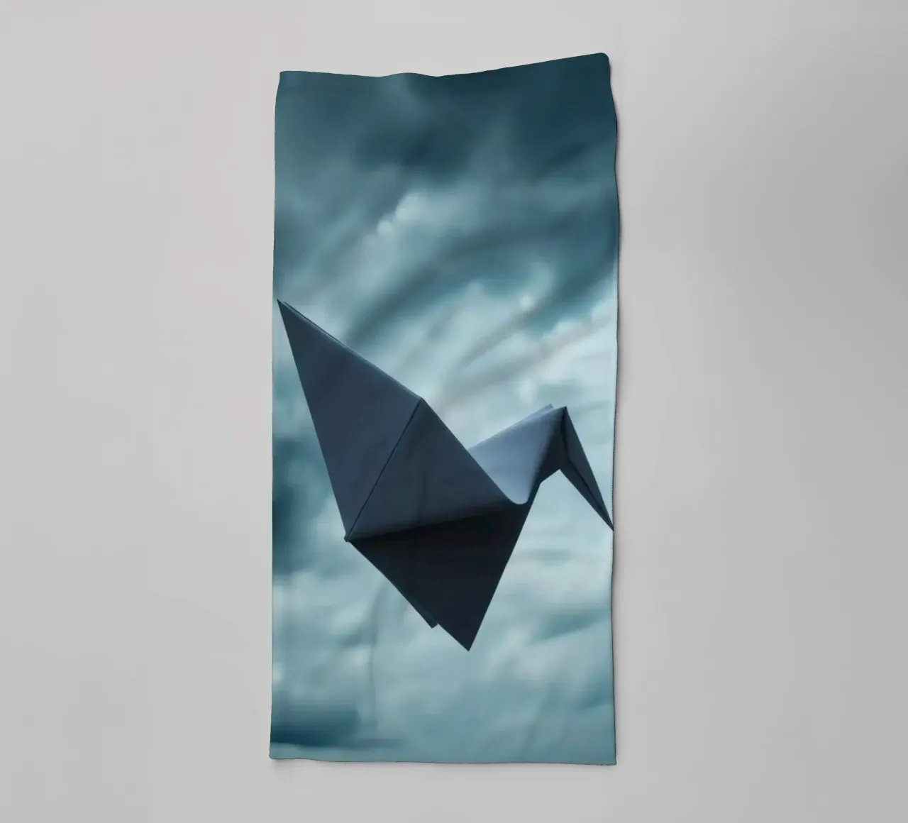 Floating origami crane against a dramatic cloudy sky towel by DesignDoodle