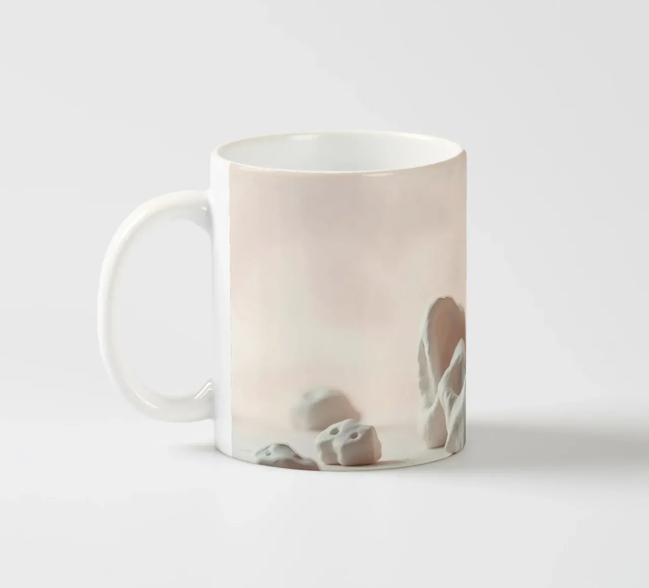 Sculture in argilla disposte su una superficie bianca con un rosa tenue tazza in ceramica da DesignDoodle