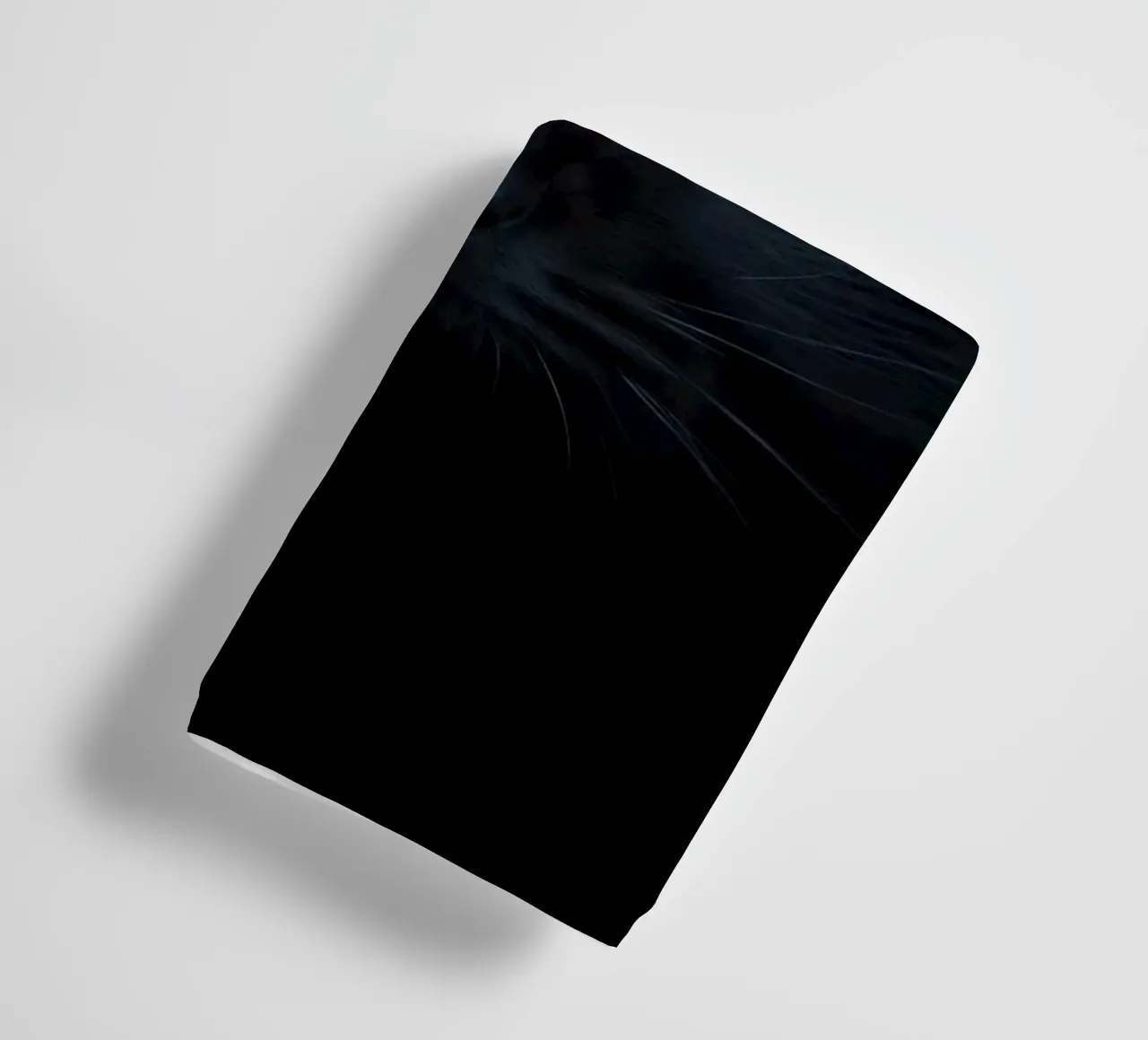 Chaton noir aux yeux bleus regardant curieusement sur un fond sombre. serviette de bain de DesignDoodle