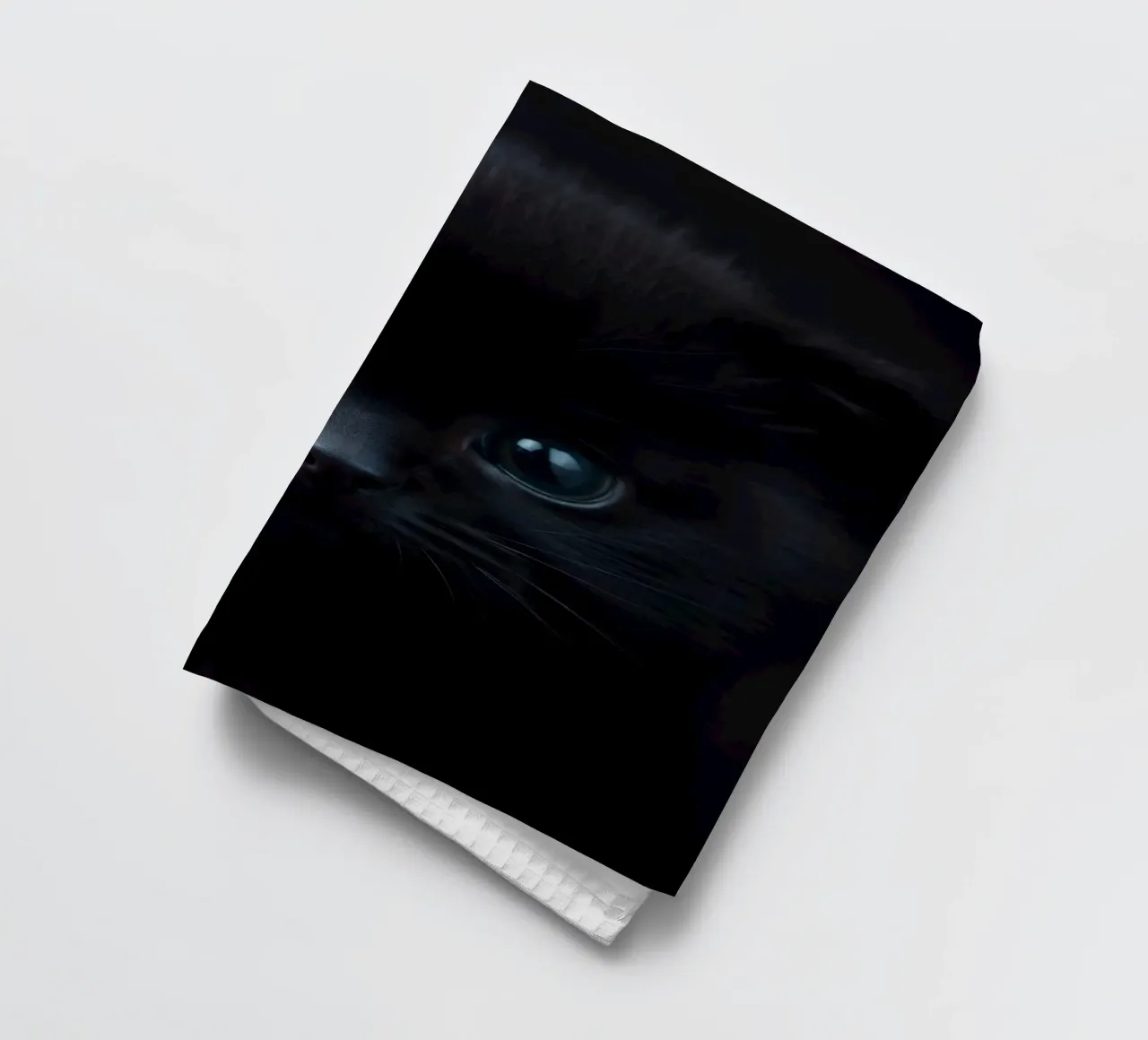 Chaton noir aux yeux bleus regardant curieusement sur un fond sombre. torchon de DesignDoodle