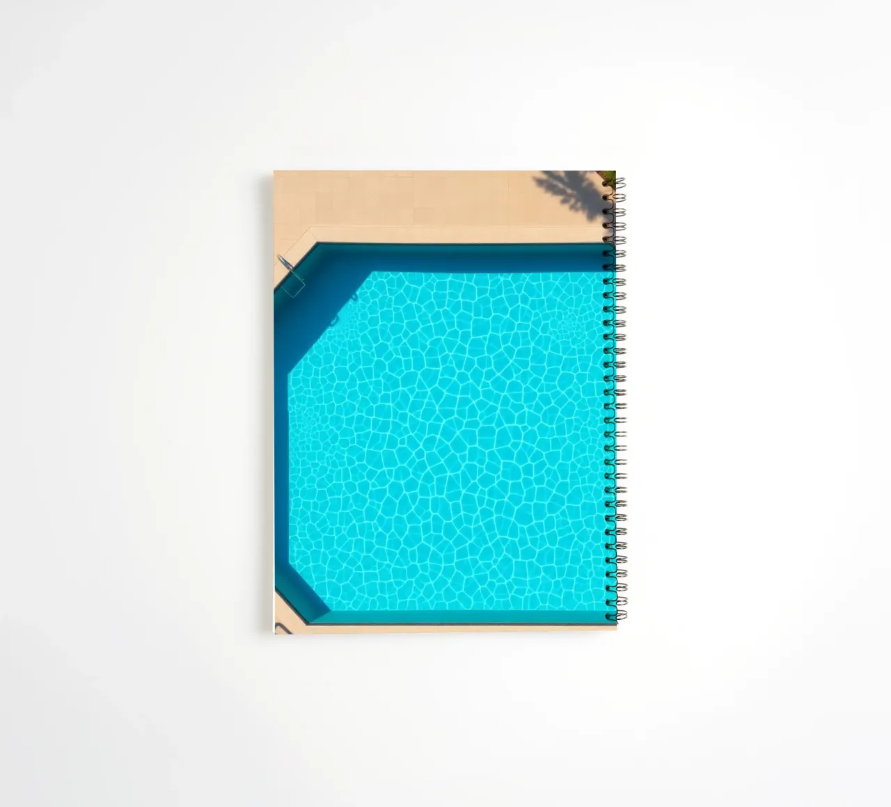 Bright blue swimming pool surrounded by a sunny patio spiral notebook by DesignDoodle